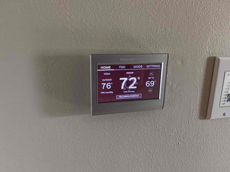 Completed HVAC system estimate for basement installation featuring existing RenewAire ventilation unit with associated ductwork and Honeywell Home digital thermostat. Assessed current equipment configuration, duct routing through exposed ceiling joists, and thermostat functionality displaying 69°F indoor temperature with 61% humidity levels. Provided comprehensive replacement options and recommendations for upgraded system components to improve climate control efficiency in the multipurpose basement space.