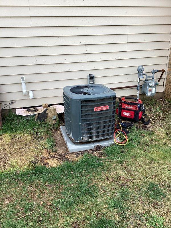 # HVAC Service Call - No Cooling Issue

Responded to a no cooling complaint on a Goodman residential air conditioning system less than 10 years old. Upon arrival, performed visual inspection of the outdoor condensing unit and discovered signs of system deterioration including rust formation on ventilation components and weathered metal surfaces. 

Connected manifold gauge set to service ports and conducted refrigerant pressure analysis to assess system performance. Evaluated both high and low-side pressures to determine if refrigerant charge, compressor function, or airflow restrictions were contributing to the cooling failure. Inspected electrical disconnect, refrigerant line sets, and condensate drainage system for proper operation.

The outdoor unit showed evidence of age-related wear on the louver grille with visible rust accumulation at base corners and paint degradation, though the unit remained structurally sound. Copper refrigerant lines and electrical conduit were examined for