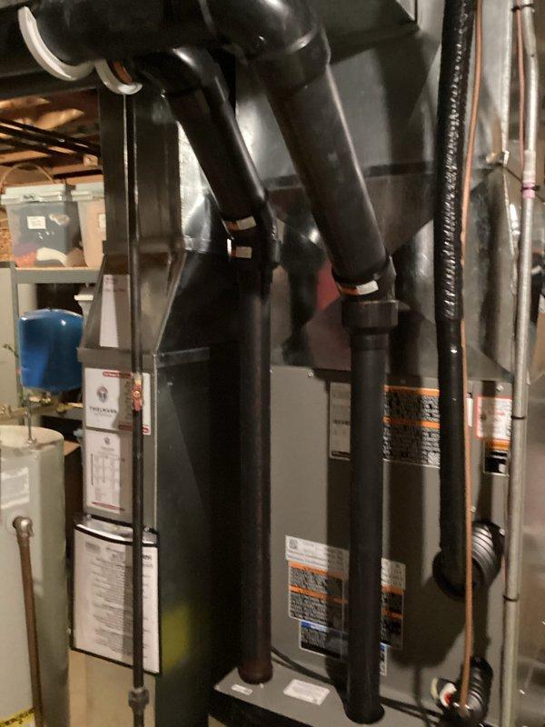 Completed HVAC system installation in residential property including new air handler unit and associated components. Installed black cylindrical air handler in basement mechanical room with proper connections to existing ductwork and electrical systems. Routed refrigerant lines and condensate drainage per manufacturer specifications. Verified all mechanical connections, tested system operation, and confirmed proper airflow throughout the residence. Installation includes integration with existing water heater and plumbing infrastructure. All equipment secured and labeled according to code requirements. System tested and operational upon completion of warranty work.