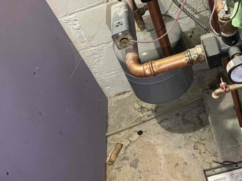 Completed comprehensive HVAC system evaluation for equipment replacement estimate in residential mechanical room. Assessment included existing water heater installation with aged copper piping connections, PVC vent system, and adjacent air handler unit positioned in confined utility space. Documented current plumbing infrastructure showing mixed materials including copper supply lines with brass fittings, black steel piping with foam insulation, and pressure relief components. Evaluated mechanical room configuration with concrete block wall construction and equipment accessibility for future replacement considerations. Photographed existing system components, pipe routing, and spatial constraints to provide accurate replacement specifications and installation planning recommendations.