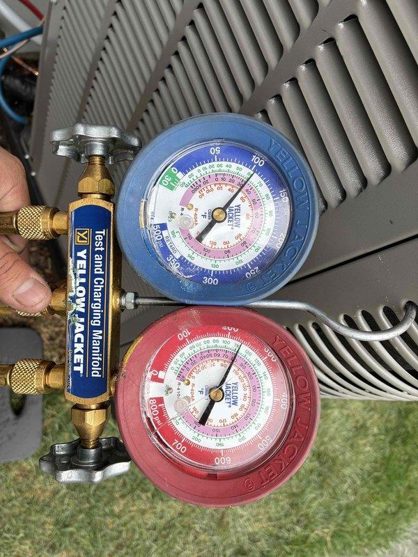Performed warranty diagnostic service on HVAC system. Connected manifold gauge set to service ports on condensing unit to measure refrigerant pressures and verify proper system operation. All pressures found within manufacturer specifications, system operating normally with no defects identified.