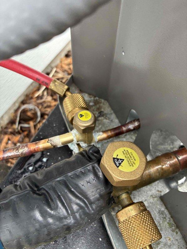 Performed warranty diagnostic service on HVAC system. Connected manifold gauge set to service ports on condensing unit to measure refrigerant pressures and verify proper system operation. All pressures found within manufacturer specifications, system operating normally with no defects identified.