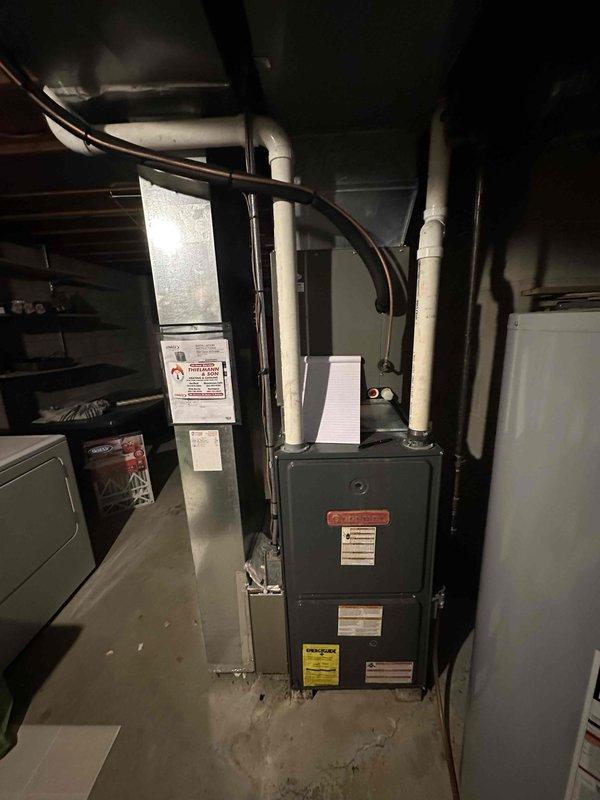 Completed full HVAC system replacement in residential basement utility area. Installed new furnace unit with associated vertical ductwork system including metal plenum boxes and galvanized duct sections running floor to ceiling. Configured white PVC condensate drain and venting lines for proper furnace operation. System has been tested and is fully operational.