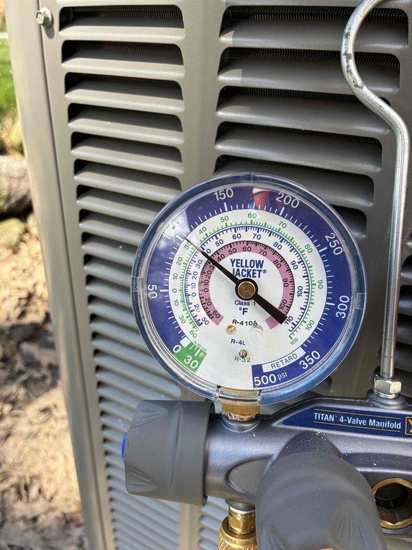 Performed warranty diagnostic service on outdoor air conditioning unit. Connected Yellow Jacket manifold gauges to measure system pressures and verify proper refrigerant charge levels across multiple refrigerant types including R-22, R-404A, and R-410A. System pressures were monitored and recorded using calibrated analog gauges reading up to 800 PSI to ensure unit was operating within manufacturer specifications and warranty compliance standards.