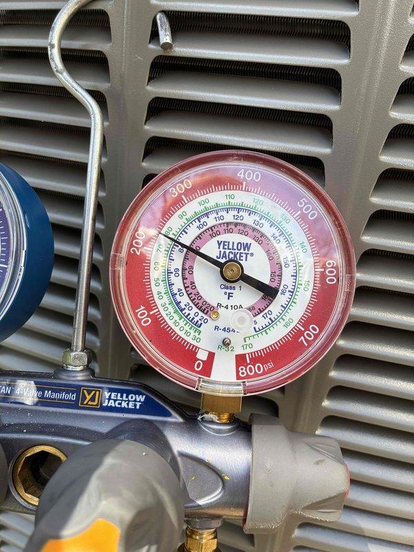 Performed warranty diagnostic service on outdoor air conditioning unit. Connected Yellow Jacket manifold gauges to measure system pressures and verify proper refrigerant charge levels across multiple refrigerant types including R-22, R-404A, and R-410A. System pressures were monitored and recorded using calibrated analog gauges reading up to 800 PSI to ensure unit was operating within manufacturer specifications and warranty compliance standards.