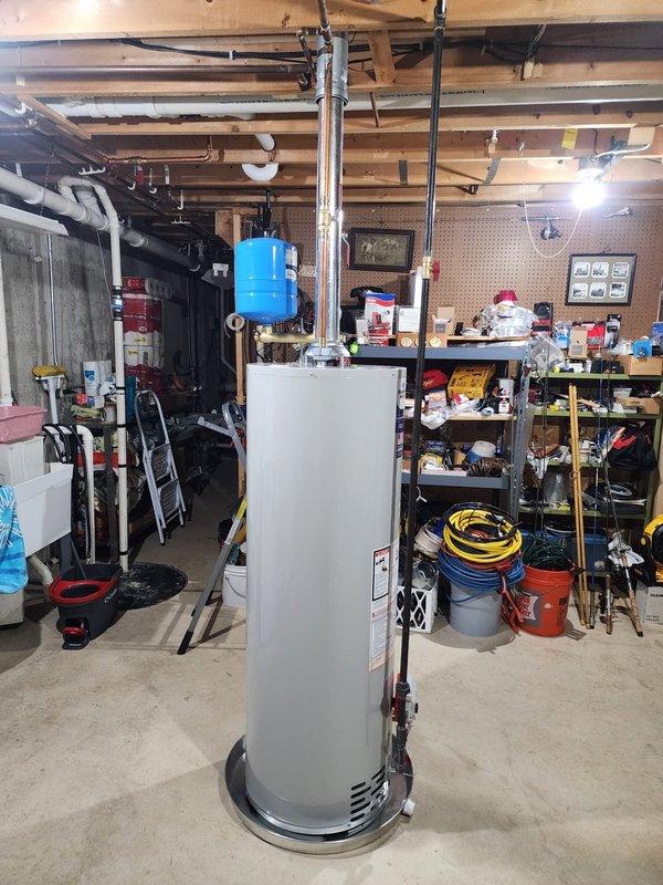 Completed installation of residential water heating system in basement utility area. Installation included mounting and connecting new water heater unit with associated copper supply lines, expansion tank, pressure relief valve, and gas piping connections. Installed blue expansion tank on supply line to protect system from thermal expansion, integrated black iron gas piping with proper shut-off valves, and verified all connections for code compliance and leak-free operation. System tested and confirmed operational upon completion.