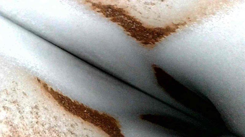 # HVAC No Heat Service Call - Unit 10+ Years Old

Responded to no heat call on aging HVAC system. Upon inspection, discovered significant rust staining on pipe insulation and surrounding surfaces, indicating prolonged moisture exposure and potential corrosion of metal components. Documented conditions with photographic evidence showing rust-colored discoloration transferred to insulation materials and adjacent ceiling areas. The extensive oxidation staining suggests active or historical water intrusion affecting system components, which may be contributing to heating system failure. Recommended further investigation of moisture source and evaluation of corroded components to restore proper heating function and prevent additional water damage to the unit.