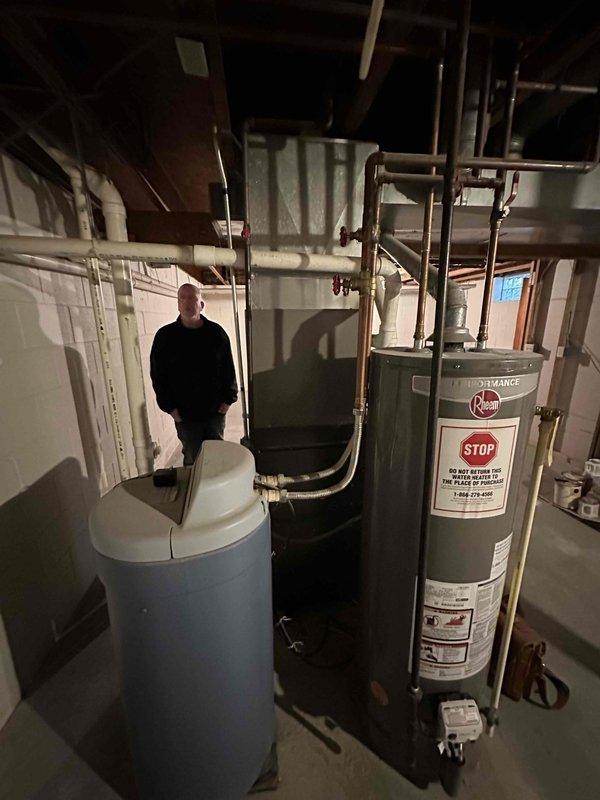 Completed on-site evaluation of existing residential HVAC system and water heater in basement mechanical room for equipment replacement estimate. Documented current Goodman furnace, air handler, associated ductwork connections, and Rheem water heater with existing copper plumbing infrastructure. Assessed equipment conditions, spatial layout, and utility connections to provide comprehensive replacement recommendations for aging heating and cooling system.