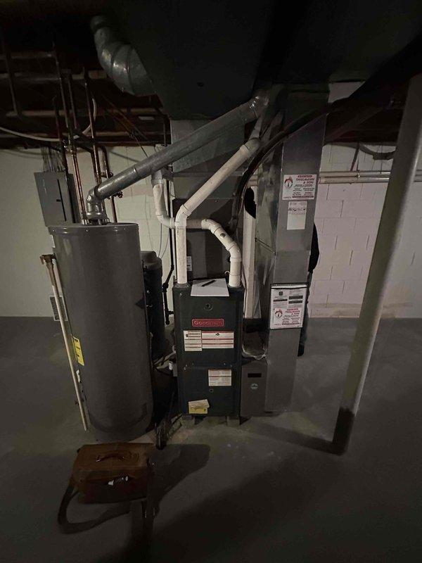 Completed on-site evaluation of existing residential HVAC system and water heater in basement mechanical room for equipment replacement estimate. Documented current Goodman furnace, air handler, associated ductwork connections, and Rheem water heater with existing copper plumbing infrastructure. Assessed equipment conditions, spatial layout, and utility connections to provide comprehensive replacement recommendations for aging heating and cooling system.