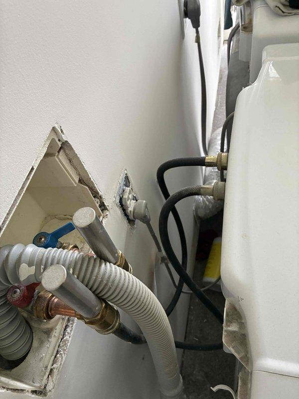 Conducted comprehensive indoor air quality assessment of residential HVAC system and mechanical room. Documented existing plumbing connections, water heater installation with brass fittings, and HVAC ductwork configuration in utility area showing signs of previous maintenance work. Evaluated exterior door conditions revealing significant weathering and paint deterioration on door frame that may contribute to air infiltration and compromise building envelope integrity, potentially impacting overall system efficiency and indoor air quality performance.