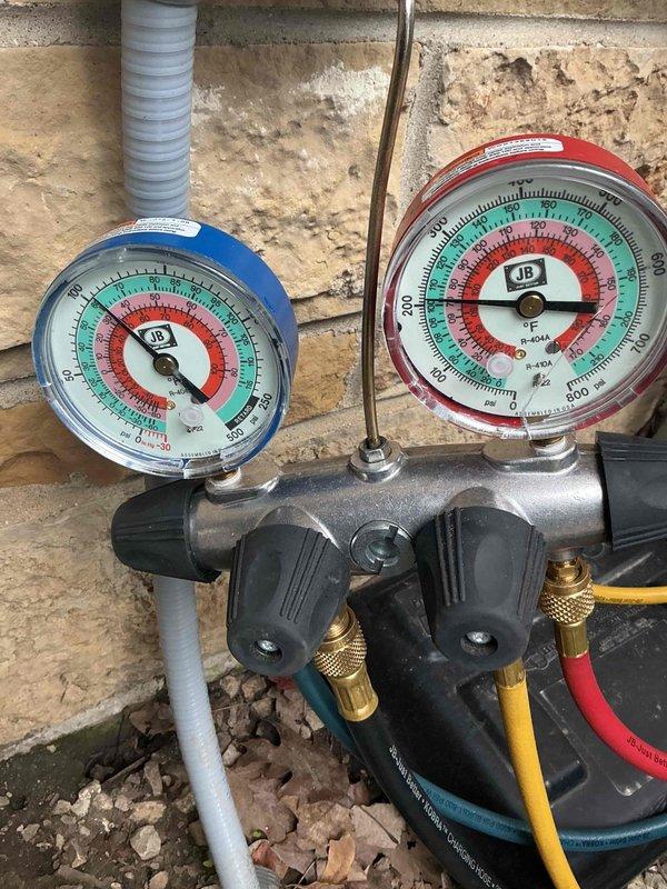Responded to no cooling complaint on residential property with three A/C systems. Upon arrival, connected manifold gauge set to outdoor condensing unit to diagnose refrigerant pressures and system operation. Performed diagnostic testing using calibrated pressure gauges to assess refrigerant charge levels and system performance. Collected equipment model numbers from all three systems on site as serial number tags were missing or illegible on some units. Documentation completed for all accessible equipment information to establish service history baseline for the property.