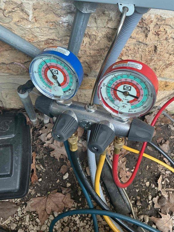 Responded to no cooling complaint on residential property with three A/C systems. Upon arrival, connected manifold gauge set to outdoor condensing unit to diagnose refrigerant pressures and system operation. Performed diagnostic testing using calibrated pressure gauges to assess refrigerant charge levels and system performance. Collected equipment model numbers from all three systems on site as serial number tags were missing or illegible on some units. Documentation completed for all accessible equipment information to establish service history baseline for the property.
