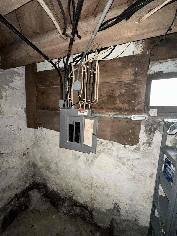 Conducted on-site assessment for mini-split installation in recently purchased home currently equipped with boiler heating system and no existing air conditioning. Evaluated basement electrical infrastructure and second-floor bedroom for optimal equipment placement, noting available electrical panel capacity and identifying suitable locations for indoor air handler unit in bedroom space with sloped ceiling configuration.