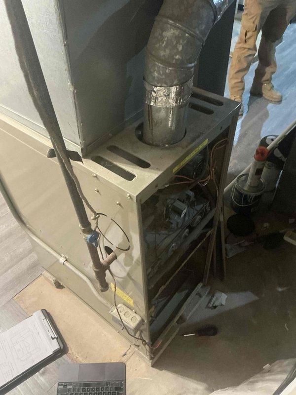 Conducted comprehensive furnace replacement estimate for residential HVAC system. Performed thorough inspection of existing furnace unit and ductwork, documenting current equipment condition including aging metal cabinet, deteriorating duct connections with visible patching, and overall system wear. Evaluated installation space, existing plenum configuration, and air handler accessibility to determine replacement specifications and equipment sizing requirements for proper system design and installation planning.