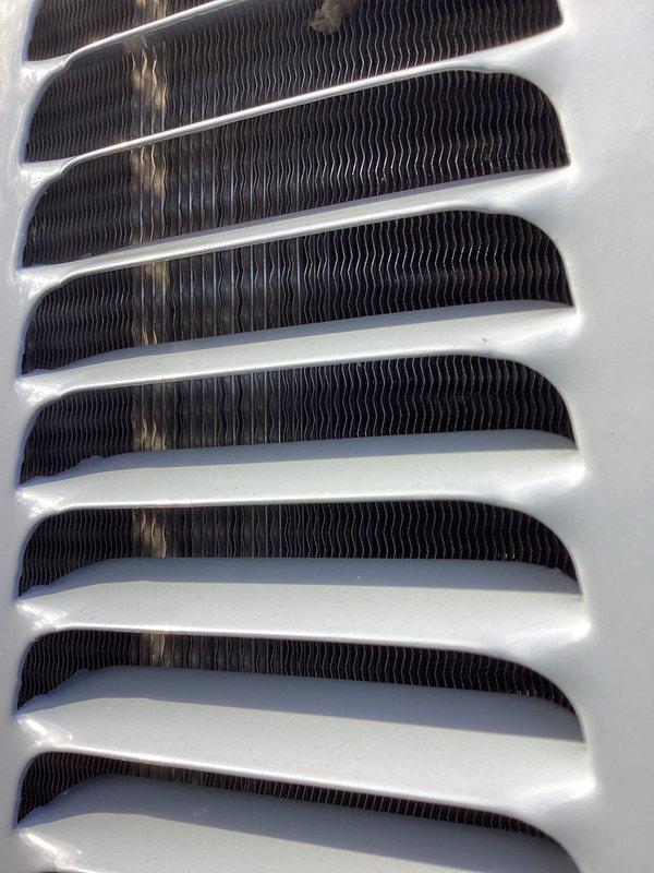 Completed annual air conditioning tune-up and maintenance inspection. Addressed customer concern regarding humidifier alert light activating intermittently; inspected humidifier system, reset controls, and verified proper operation. Documented condition of return air grille showing dust accumulation and heat exchanger coil assembly in serviceable condition.