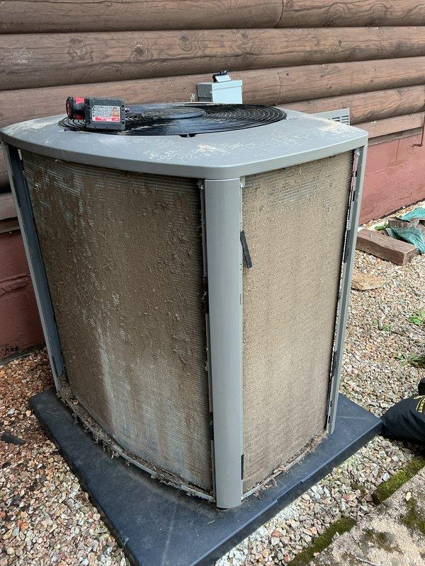 Performed membership cooling system maintenance visit on outdoor condensing unit. Upon arrival, verified previous technician's assessment regarding dirty coil condition. Inspected condenser unit and confirmed significant accumulation of dirt, dust, and debris on exterior mesh filters and coil surfaces, with heavy discoloration and clogging evident on both accessible sides. Cleaned condenser coils and filters to remove built-up contaminants and restore proper airflow through the unit. Documented equipment condition with photographs showing before state of heavily soiled components. Unit operational following cleaning service.