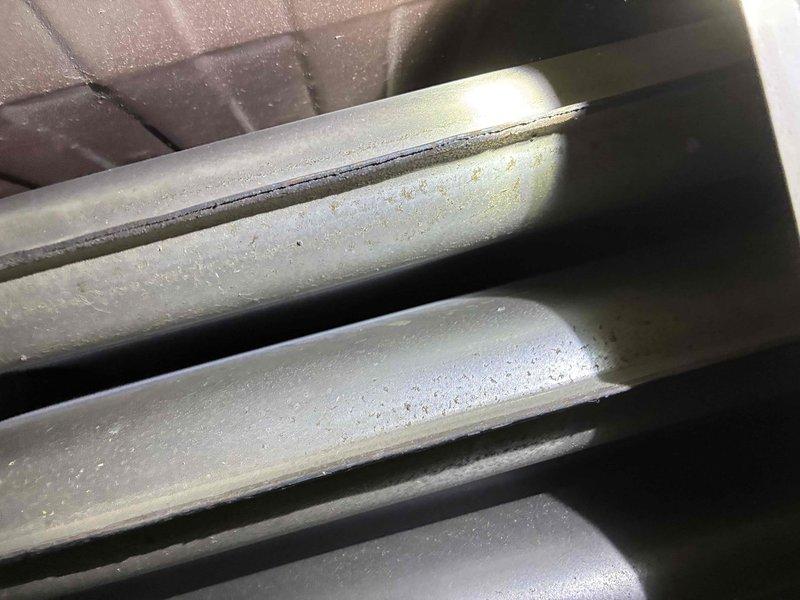 Responded to service call for 1996 Lennox furnace with reported noise issue. Upon inspection, identified signs of heat exchanger deterioration with visible discoloration around burner ports and age-related oxidation on metal surfaces. Documented condition of curved heat exchanger tubes showing accumulated dust and wear consistent with 28-year-old unit, indicating potential safety concerns and end-of-service-life conditions requiring replacement recommendation.