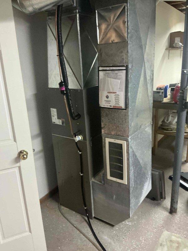Responded to no-heat emergency call for 15-year-old furnace with failed blower motor. Completed full system replacement installation in basement mechanical room, including new furnace unit with metal ductwork connections and refrigerant line routing. Existing water heater remained in place during furnace changeout, with all new equipment positioned on concrete floor and properly integrated with existing duct distribution system throughout the residence.