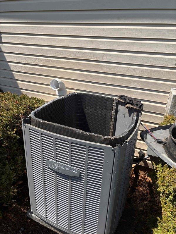 Performed routine maintenance tune-up on Armstrong outdoor condensing unit. Upon inspection, discovered severely deteriorated condenser coil with extensive fin damage, accumulated debris, and compromised heat transfer surfaces requiring immediate attention. Documented equipment condition with photographic evidence showing significant degradation of coil assembly and surrounding components.