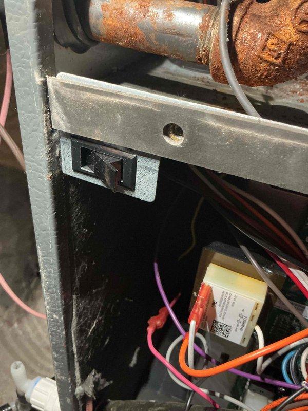 Completed warranty replacement of furnace door safety switch assembly on Daikin residential heating unit. Installed new door switch with mounting bracket to restore proper safety interlock function. Unit tested and verified operational upon completion of installation.