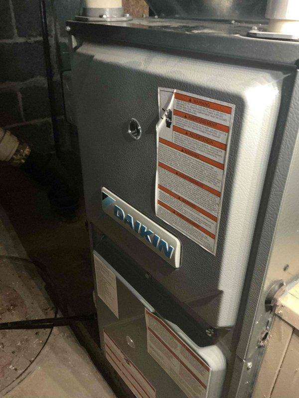 Completed warranty replacement of furnace door safety switch assembly on Daikin residential heating unit. Installed new door switch with mounting bracket to restore proper safety interlock function. Unit tested and verified operational upon completion of installation.