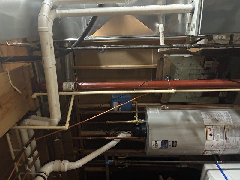 Completed installation of dual-tank water treatment and filtration system in residential basement utility area. System includes two fiberglass filtration tanks with digital control valve, integrated with existing plumbing infrastructure and water heater. All piping connections, electrical components, and control panel successfully installed and tested for proper operation.
