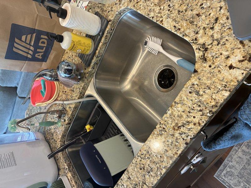 Performed on-site assessment for kitchen sink and faucet replacement estimate. Inspected existing undermount stainless steel sink installation, evaluated under-cabinet plumbing configuration including supply lines and drainage system, and documented current fixture conditions. Assessed countertop penetrations and cabinet space constraints for new fixture installation, and evaluated ventilation requirements for countertop application as requested.