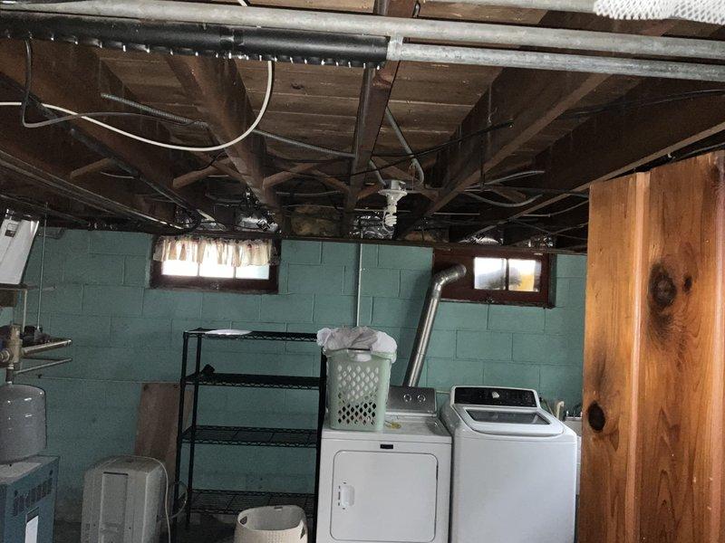 Conducted on-site assessment for residential cooling solution in two-story home with existing chimney-vented boiler system. Evaluated upstairs area with four bedrooms experiencing excessive heat issues and reviewed basement mechanical space with exposed joists, existing ductwork, and utilities. Recommended hybrid approach consisting of ducted mini-split system for second floor bedrooms and ductless mini-split units for first floor, with consideration for potential soffit installation or attic fan to address ventilation concerns and improve overall climate control efficiency.