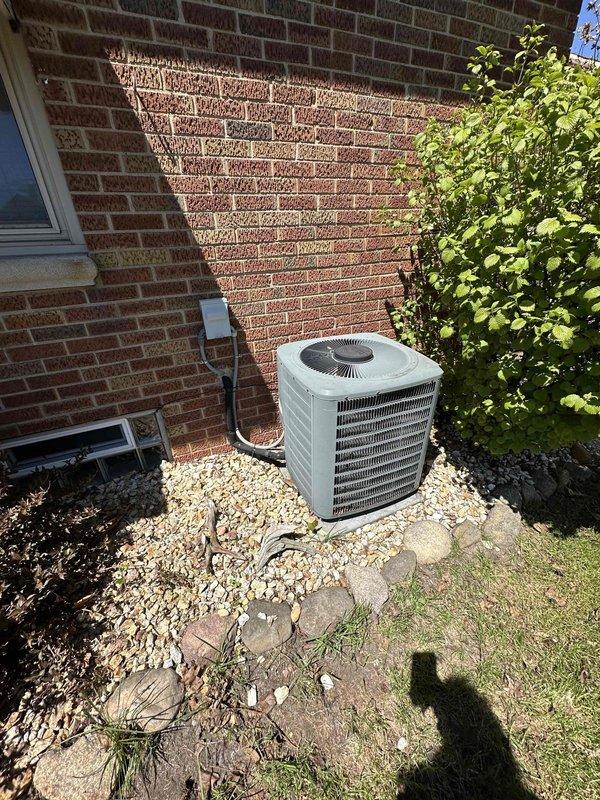 Provided comprehensive estimate for complete HVAC system replacement including furnace and air conditioning unit, both over 20 years old. Assessed existing natural gas furnace with humidifier attachment in basement utility area and evaluated outdoor condensing unit positioned on gravel pad against brick exterior. Documented current system configuration including ductwork, refrigerant lines, and electrical connections to determine replacement specifications and scope of work.