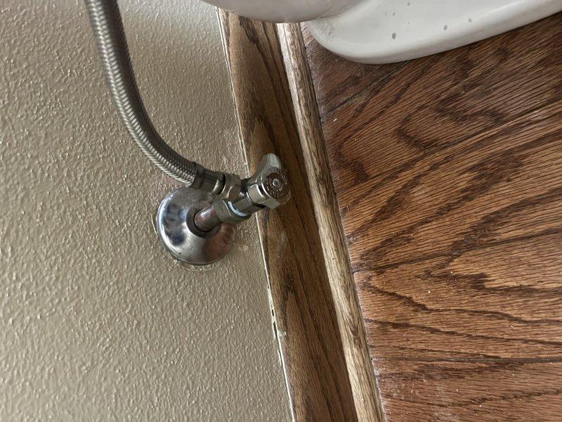Installed water softener system in utility space with proper mounting brackets and secure positioning. Replaced toilet angle stop valve at wall connection point with chrome-finished fixture and connected braided flexible supply line. Completed tub trim installation. All plumbing connections tested for proper operation and verified no leaks present at angle stop valve or water softener connections.