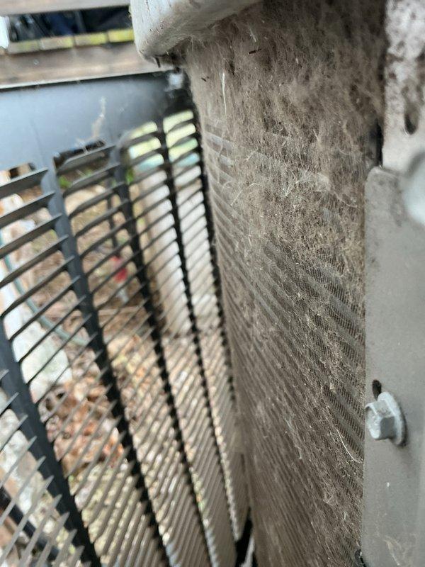 Completed routine AC tuneup and maintenance visit for recurring membership customer. Upon arrival, found outdoor condenser unit with heavily soiled coils showing significant accumulation of dirt, debris, moss, and algae growth, particularly at the base where moisture had collected. Inspected condenser fins and found substantial environmental buildup affecting airflow and heat exchange efficiency. Documented pre-service condition with photographs showing the extent of contamination on both the exterior coil surfaces and air filtration components. Cleaned condenser coils, removed organic growth and debris, and restored proper airflow to the unit to ensure optimal cooling performance for the season.