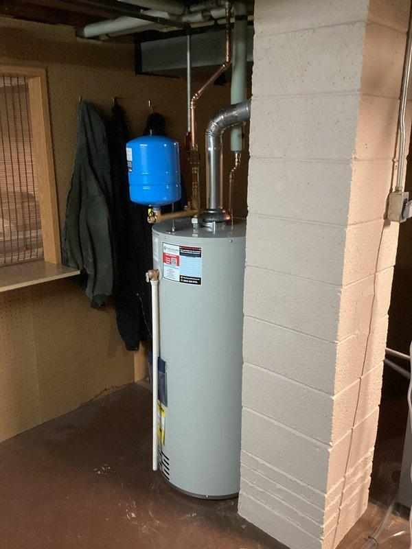Completed installation of new residential water heater in basement utility room. Installation included proper venting with metallic duct, copper supply line connections, integration with existing blue expansion tank, and verification of all plumbing connections per manufacturer specifications and local code requirements.