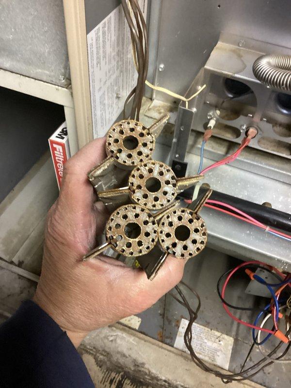Completed furnace and air conditioning tune-up maintenance on residential HVAC system. Removed and inspected gas burner assembly, which consisted of four circular brass burner heads with proper hole patterns and central openings. Verified gas valve operation, checked all electrical connections and wiring throughout the unit, and inspected flexible gas line and fittings for proper installation and safety. Cleaned burner assembly, reassembled unit, and confirmed proper system operation. Provided estimate for duct cleaning services per customer inquiry.