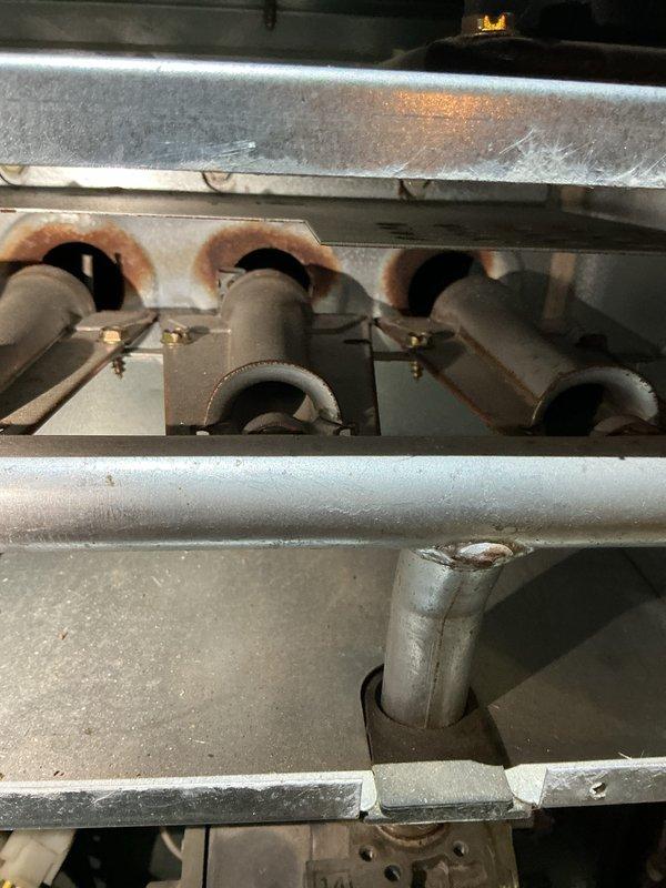 Completed furnace and air conditioning tune-up maintenance service. Performed combustion analysis on natural gas heating system, confirming optimal efficiency at 93.3% with acceptable flue gas readings: oxygen at 7.6%, carbon monoxide at 3 ppm, and stack temperature at 106.5°F. Inspected burner assembly, noting rust staining around burner ports indicative of normal aging but requiring monitoring for future maintenance needs.