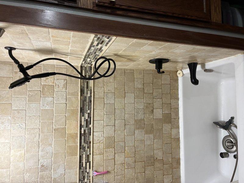 Responded to service call for non-functional tub spout in bathroom shower/tub combination. Upon arrival, performed diagnostic assessment of existing shower trim assembly and plumbing connections. Attempted replacement of complete shower trim kit to resolve issue; however, determined that underlying rough-in plumbing configuration was incompatible with new trim components. Accessed basement utility area to inspect supply lines and valve assembly behind shower wall. Identified aged brass valve with cross-handle showing significant corrosion and buildup on copper supply piping. Confirmed that existing plumbing infrastructure requires modification before proper trim installation can be completed. Coordinated scheduling for return visit to address rough-in plumbing corrections necessary for successful shower system restoration.