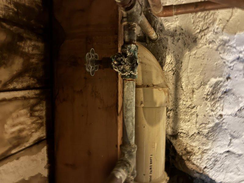 Responded to service call for non-functional tub spout in bathroom shower/tub combination. Upon arrival, performed diagnostic assessment of existing shower trim assembly and plumbing connections. Attempted replacement of complete shower trim kit to resolve issue; however, determined that underlying rough-in plumbing configuration was incompatible with new trim components. Accessed basement utility area to inspect supply lines and valve assembly behind shower wall. Identified aged brass valve with cross-handle showing significant corrosion and buildup on copper supply piping. Confirmed that existing plumbing infrastructure requires modification before proper trim installation can be completed. Coordinated scheduling for return visit to address rough-in plumbing corrections necessary for successful shower system restoration.