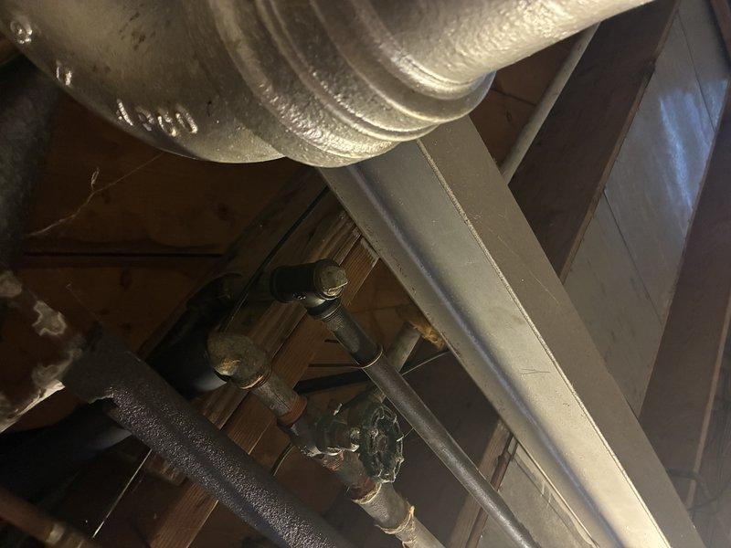 Responded to no hot water issue in primary bathroom shower/tub. Upon inspection, found mineral buildup had locked the mixing valve in place, preventing hot water flow to the fixture. Disassembled shower trim and faucet components to access the affected valve cartridge. Removed corroded parts and assessed the existing copper supply lines, noting narrow pipe diameter and age-related deterioration in several sections. Documented conditions of both the fixture assembly and accessible plumbing infrastructure in the crawl space above, including supply line routing and connections. Provided assessment of plumbing system condition and repair options to address both the immediate hot water issue and underlying concerns with aging copper piping.