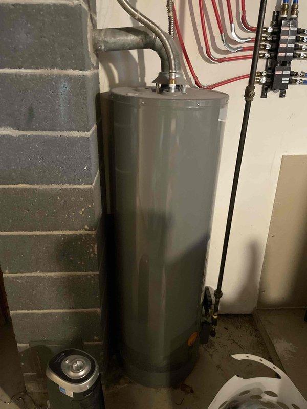 Conducted on-site assessment of residential water heater experiencing active leak causing water damage to floor. Documented existing installation including plumbing connections, PEX distribution manifold, and current drain pan configuration. Provided estimate for complete water heater replacement including removal of failed unit, installation of new water heater with proper venting and connections, and integration with existing radiant heating distribution system.