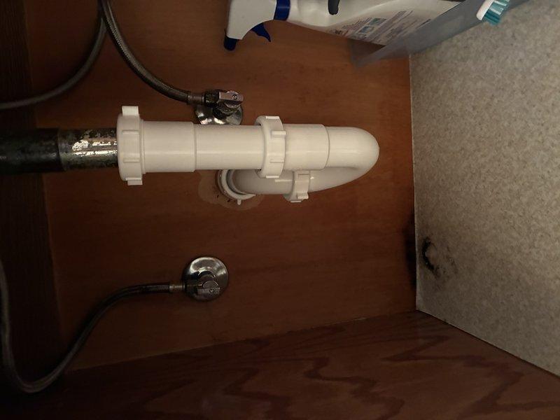 Completed faucet cartridge replacement on bathroom sink fixture with chrome finish and porcelain cross-handles. Serviced both hot and cold water cartridges, tested operation for proper flow and temperature control, and verified all connections under sink including supply lines and P-trap assembly for leaks. All components functioning properly upon completion.