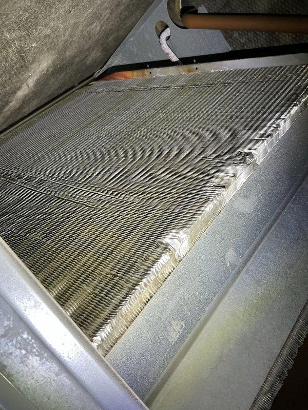 Completed annual tune-up maintenance on residential HVAC system with attic-mounted air handler and ground-level condenser unit. Accessed evaporator coil in attic using ladder, inspected coil fins which showed moderate dust accumulation, cleaned condenser unit exterior using 100-foot hose, and replaced air filter. Both indoor and outdoor components were inspected and found to be operating within normal parameters following routine maintenance procedures.