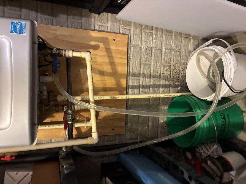 Performed on-site evaluation and provided estimate for descaling service on tankless water heater unit. Inspected unit's digital control panel displaying system parameters and assessed overall equipment condition. Evaluated existing plumbing connections, PVC piping configuration, and water treatment system integration to determine descaling requirements and service approach.