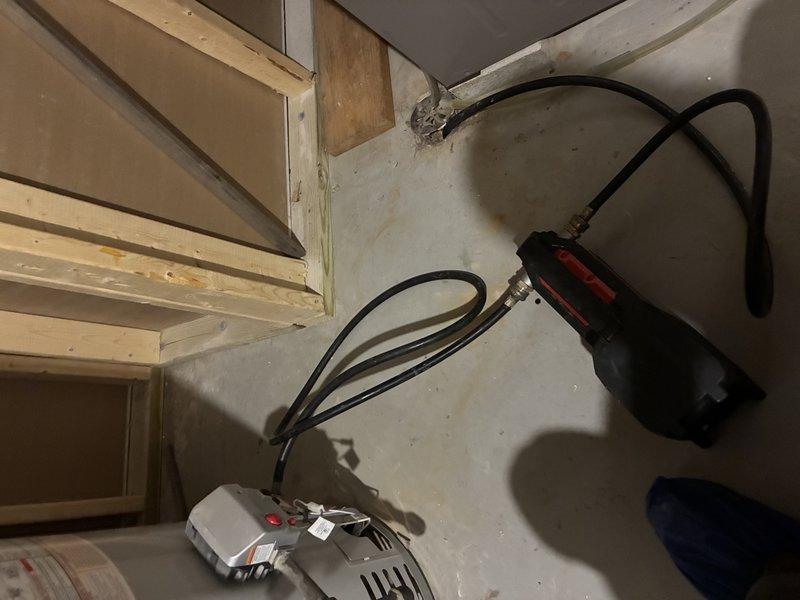 Performed on-site assessment of residential water heater located in basement utility area to provide estimate for water heater flush service. Inspected white cylindrical electric water heater unit, examined manufacturer specifications, control panel, and warning labels to determine maintenance requirements. Documented current condition of unit and surrounding mechanical equipment area through photographic documentation for estimate preparation purposes.