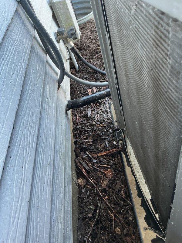 Completed prepaid membership cooling maintenance visit on residential AC condenser unit. Inspected outdoor unit which showed significant dirt and debris accumulation on intake filter screen and surrounding area. Noted heavy buildup of organic material, wood chips, and mulch around unit base and in adjacent utility channel. Performed standard cooling season preventive maintenance including filter cleaning, coil inspection, and operational verification. Unit operational upon completion of service.