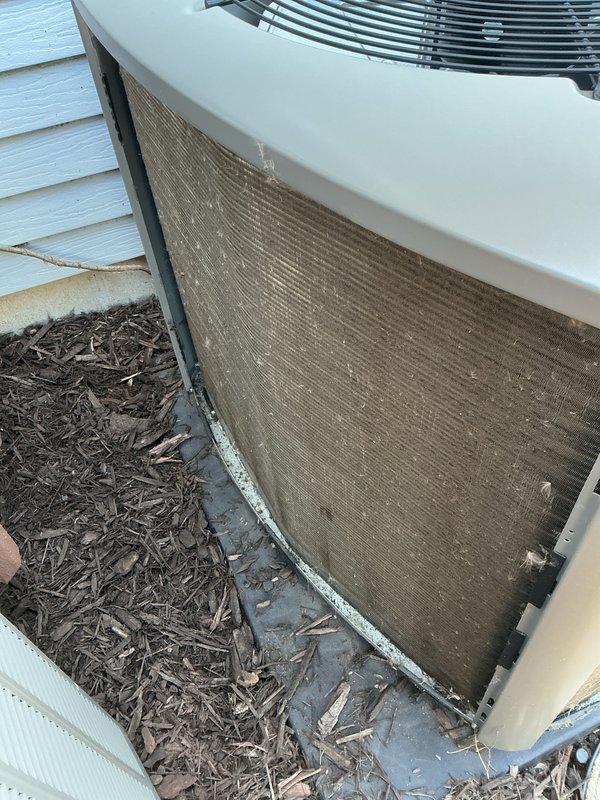 Completed prepaid membership cooling maintenance visit on residential AC condenser unit. Inspected outdoor unit which showed significant dirt and debris accumulation on intake filter screen and surrounding area. Noted heavy buildup of organic material, wood chips, and mulch around unit base and in adjacent utility channel. Performed standard cooling season preventive maintenance including filter cleaning, coil inspection, and operational verification. Unit operational upon completion of service.