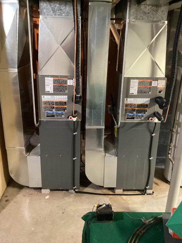 Completed installation of two new Daikin HVAC systems in residential basement, including air handler units mounted on concrete block bases with proper ductwork transitions and venting. Both units were installed side by side to serve separate zones, with all electrical connections, PVC exhaust/intake venting, and sheet metal ductwork professionally routed and secured per manufacturer specifications.