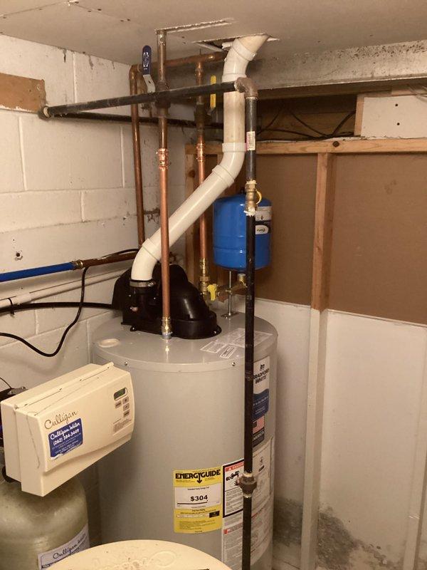 Completed installation of a Bradford White 50-gallon power vented atmospheric storage water heater, model M61W50S6N19, with 40,000 BTU/hr input rating. Installed power vent assembly with PVC venting system, connected copper supply and discharge lines with brass fittings, and mounted blue expansion tank to system. All connections tested and verified for proper operation and code compliance.