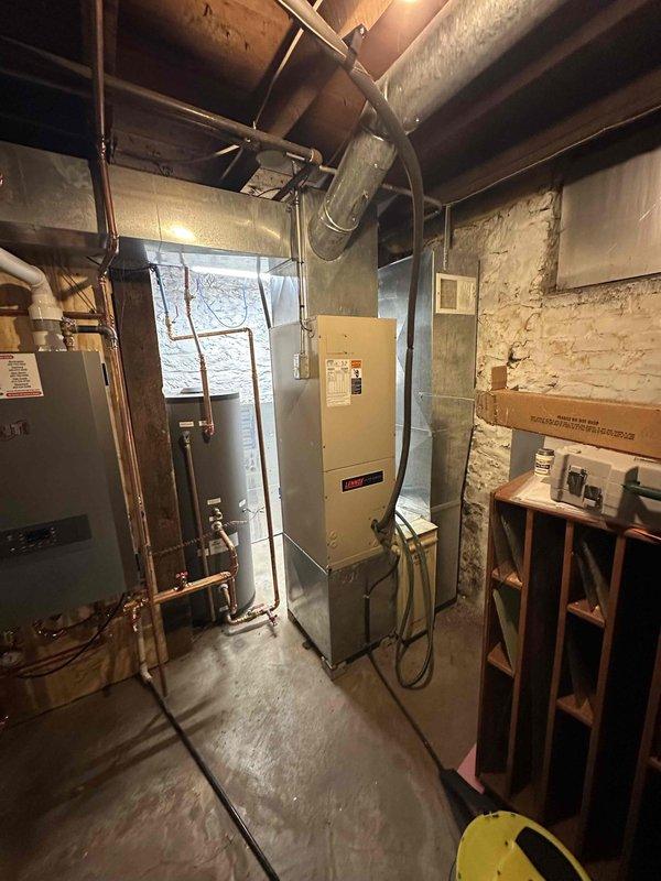 Conducted comprehensive estimate for complete HVAC system replacement at residential property. Evaluated existing boiler-based heating system with air handler for conversion to central air conditioning with new ductwork installation. Assessed basement mechanical room containing current equipment including aged HVAC unit, existing copper piping infrastructure, and electrical panel configuration. Inspected exterior location for outdoor condensing unit placement against brick exterior wall with existing concrete pad and electrical disconnect box. Provided detailed replacement specifications for transitioning from boiler system to complete forced-air heating and cooling system with appropriate ductwork design for optimal airflow distribution throughout residence.