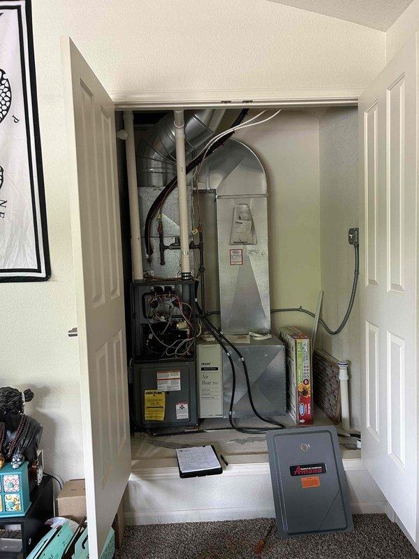 Responded to emergency no-cooling call at condominium unit with ground-level condenser installation. Conducted comprehensive assessment of existing HVAC system housed in interior utility closet, including dark-colored furnace unit, gray air handler, and associated ductwork and electrical components. Provided detailed replacement estimate for complete system, noting requirement to reuse existing lineset due to condo configuration and accessibility constraints. Documented current equipment condition, electrical panel setup, and ductwork configuration through photographic records to support replacement specifications and ensure accurate equipment sizing for proposal.