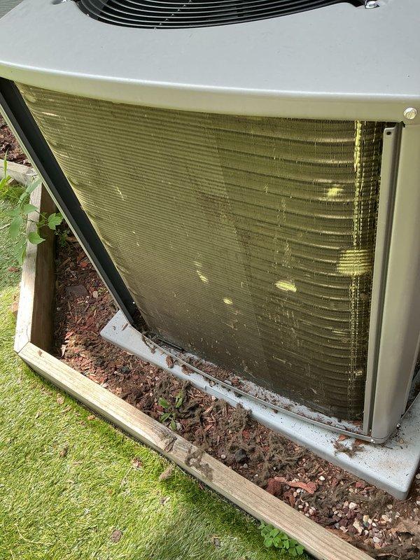 Completed routine cooling system maintenance visit on residential air conditioning unit. Upon arrival, found condenser coils heavily contaminated with pollen, dirt, and organic debris causing significant airflow restriction. Removed front access panel to assess internal components and documented extensive buildup on fin surfaces with visible discoloration throughout coil array. Performed thorough coil cleaning to restore proper heat exchange efficiency and airflow capacity. Inspected compressor assembly, fan operation, and overall unit condition. System returned to optimal operating parameters following maintenance procedures.