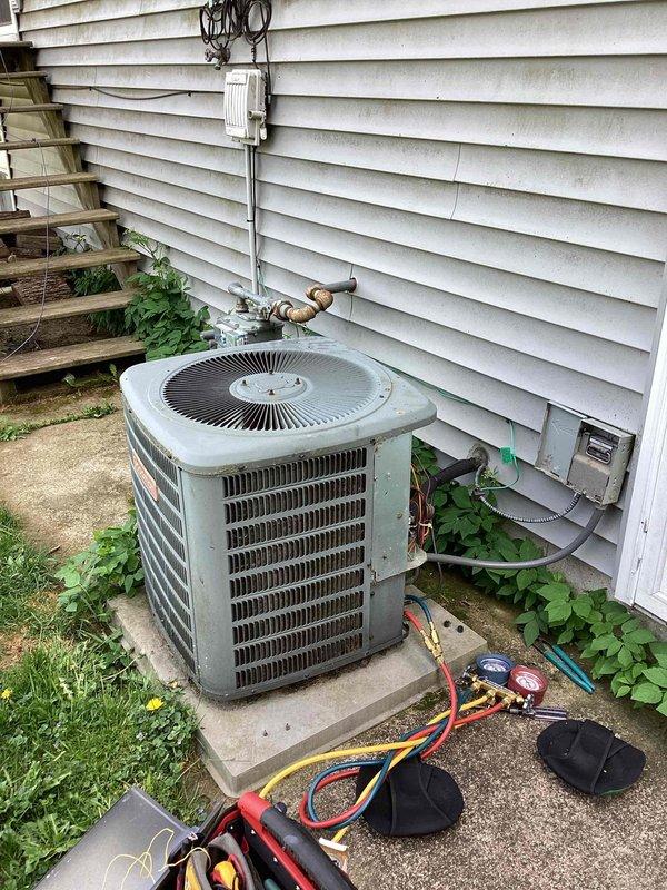 Responded to no cooling complaint on residential air conditioning system. Upon arrival, found aged outdoor condenser unit with visible weathering and dirt accumulation on coils and surfaces. Connected manifold gauge set to service ports on refrigerant lines to diagnose system performance. Performed visual inspection of unit revealing signs of extended outdoor exposure and potential maintenance neglect. Evaluated refrigerant pressures and system operation to determine root cause of cooling failure on aging equipment exceeding 10 years of service life.